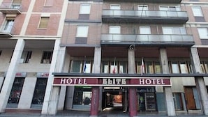 A multi-story hotel building with balconies and a ground-level entrance labeled "HOTEL ELITE HOTEL".