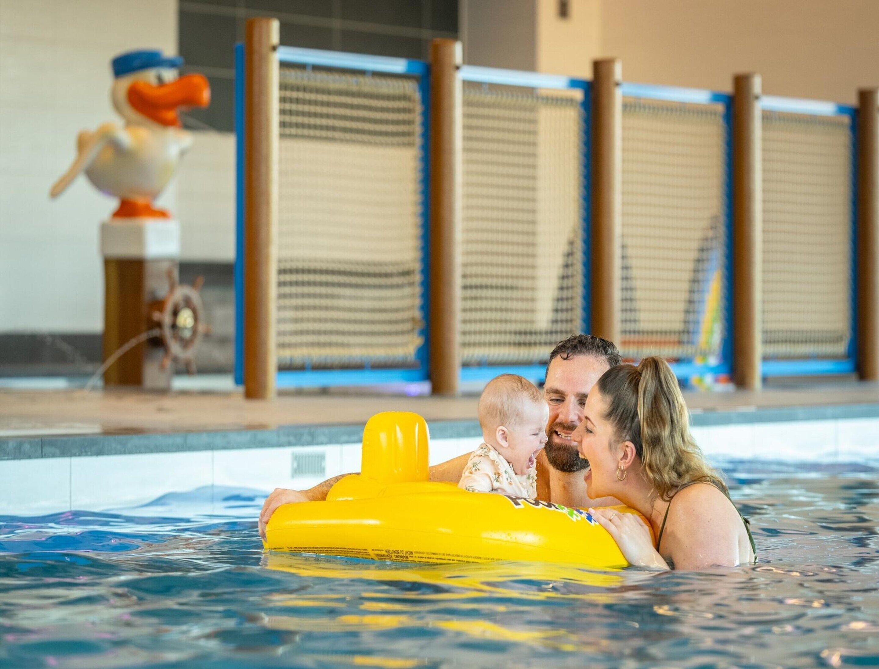Ein Schwimmbecken mit einem gelben Luftmatratzen und einer Enten-Dekoration.
