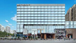 A modern hotel with a glass facade, multiple floors, and a prominent signage at the top. - Zhonghao International Hotel  (Dongguan)