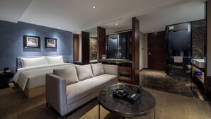 A modern hotel room with a bed, sofa, and a small dining area. - Zhonghao International Hotel  (Dongguan)
