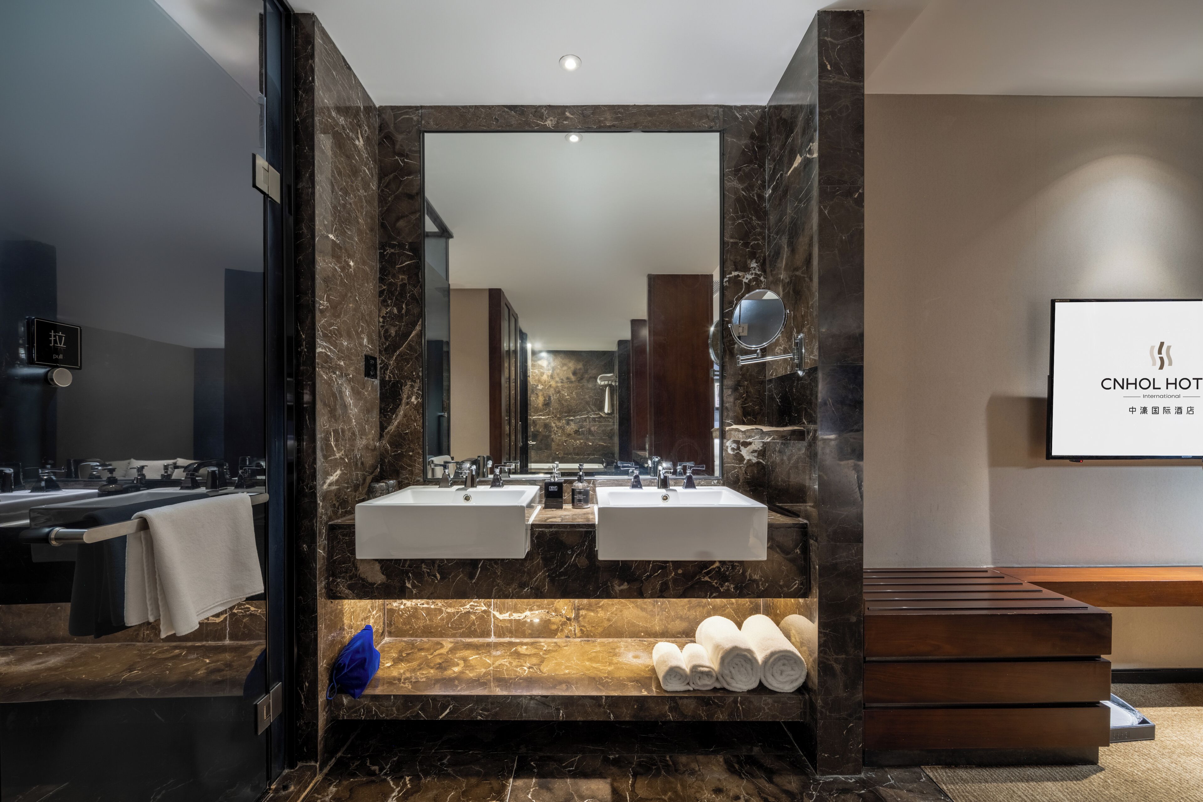 Un baño moderno con dos lavamanos, un espejo grande y encimera de mármol.