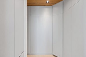 A narrow hallway with a wooden ceiling and white walls.