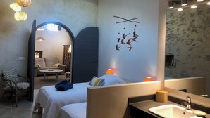 A modern hotel room with a large mirror, a bed with white linens, a small round table, and a chair. - Logis de Charlise (Vallabrix)