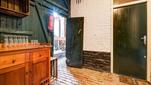 Una zona de bar rústica con armarios de madera y suelo de ladrillo.