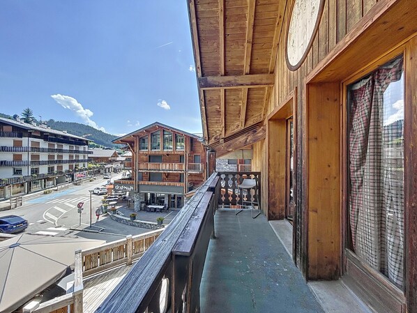 Un bâtiment en bois doté de balcons donnant sur une rue et une montagne.