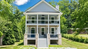 Une maison à deux étages avec un porche à l’avant, une cheminée et le numéro « 2626 » sur la porte d’entrée.