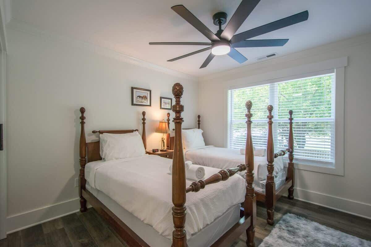Quarto com cama de dossel, ventilador de teto e janela com persianas.
