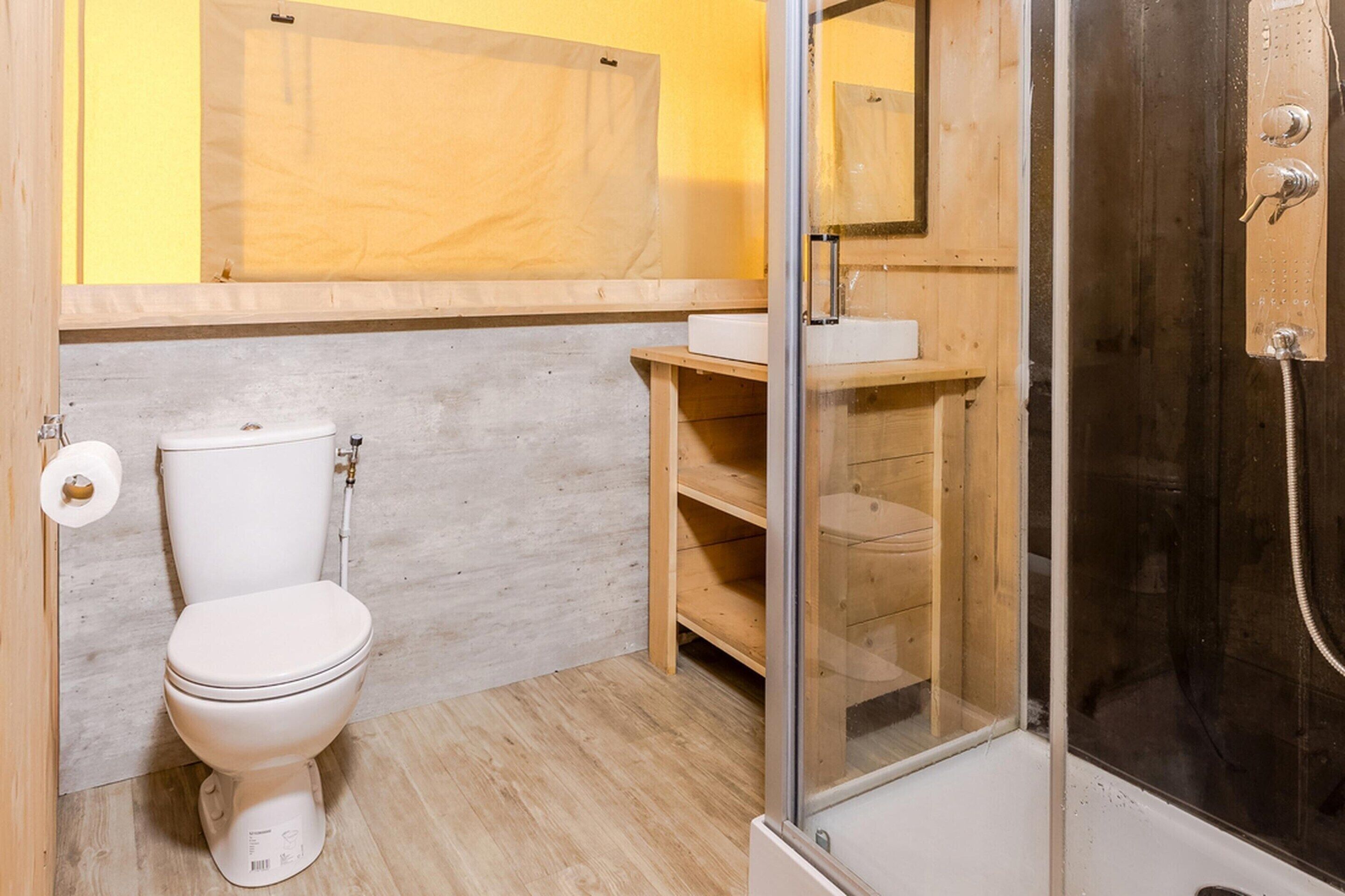 A bathroom with a toilet, sink, and shower.