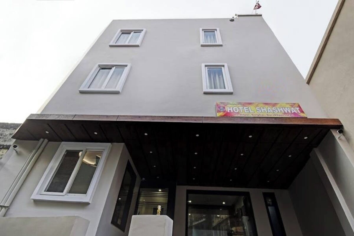 A hotel named HOTEL SHASHWAT with a modern facade, multiple windows, and a covered entrance.