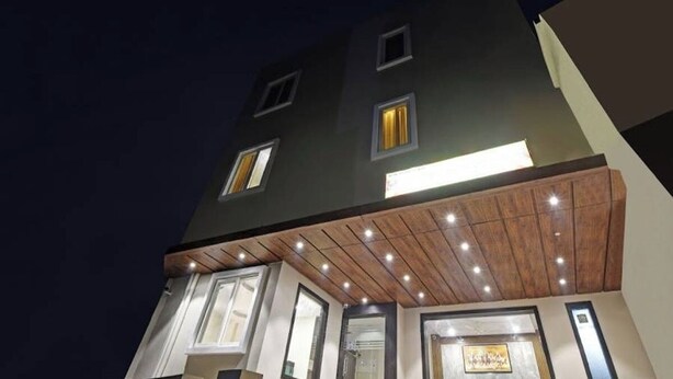 A multi-story building with illuminated windows and a wooden ceiling. - Hotel Shashwat (Gorakhpur)