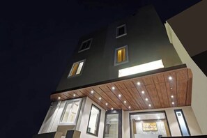A multi-story building with illuminated windows and a wooden ceiling. - Hotel Shashwat (Gorakhpur)