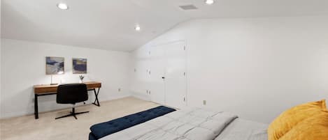 Un dormitorio con cama, escritorio, silla y armario.