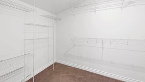 A room with multiple white wire shelving units against the walls, a carpeted floor, and a plain white ceiling. - Stunning Sammamish Lake View Home near Weowna Park (Bellevue)