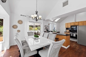 A spacious kitchen with a central island, wooden cabinets, and a stainless steel refrigerator. - Stunning Sammamish Lake View Home near Weowna Park (Bellevue)