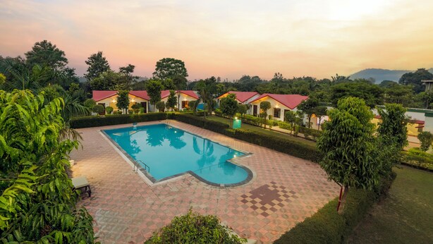 A swimming pool with a geometric design, surrounded by a checkered tile patio. - Corbett Holiday Forest Resort (Belparao)