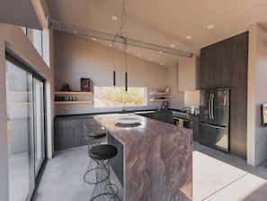 Enjoy cooking in this well-equipped kitchen with a sleek island, stainless steel appliances, and ample storage.