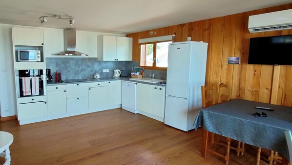 A compact kitchen with white cabinets, a microwave, a stove, a sink, and a refrigerator. - Front row in Lège Cap Ferret, between the dunes and the beach (Lège-Cap-Ferret)
