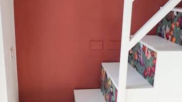 Una escalera con escalones blancos y un rellano con estampado floral.