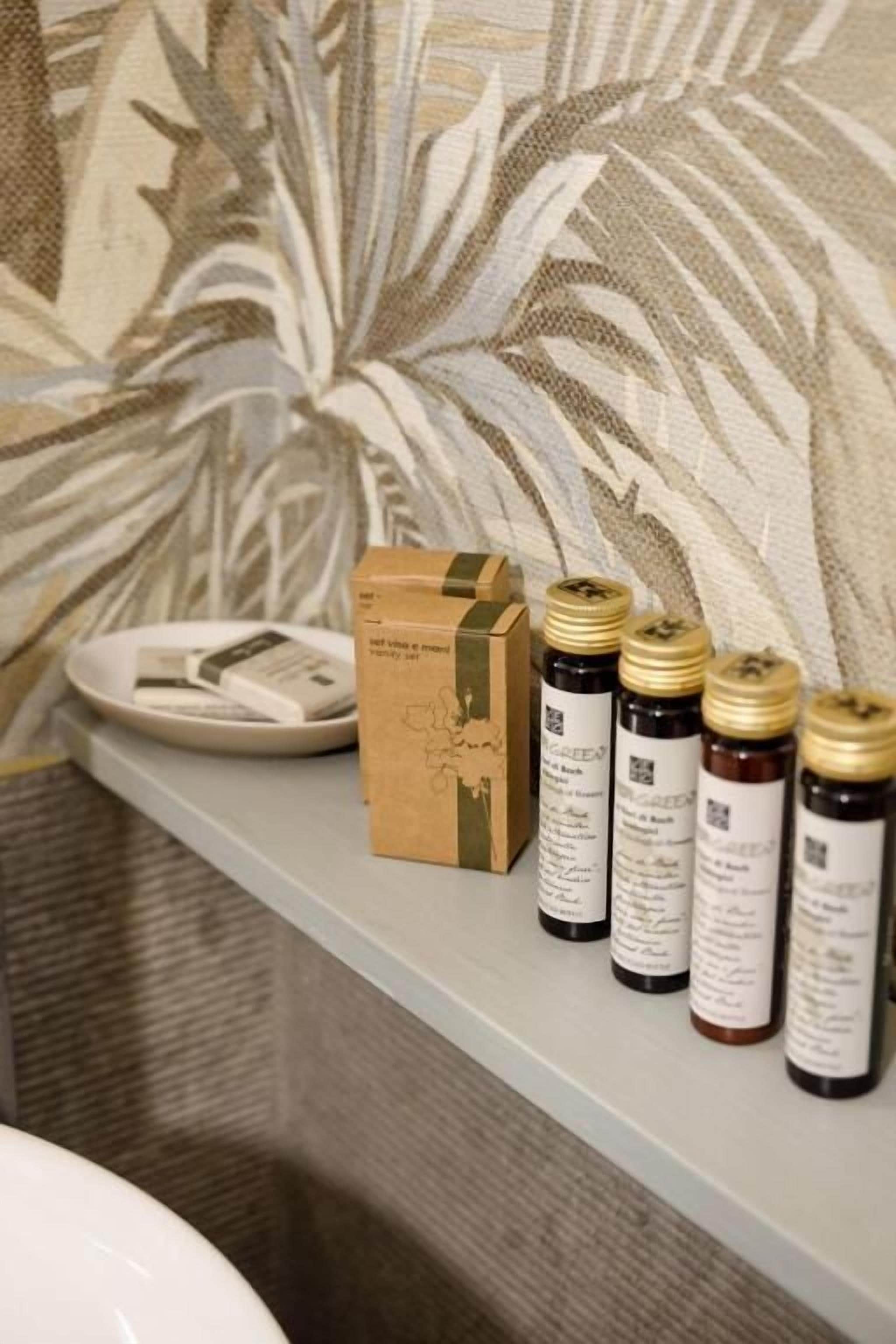 A bathroom shelf with a box and several bottles of essential oils.