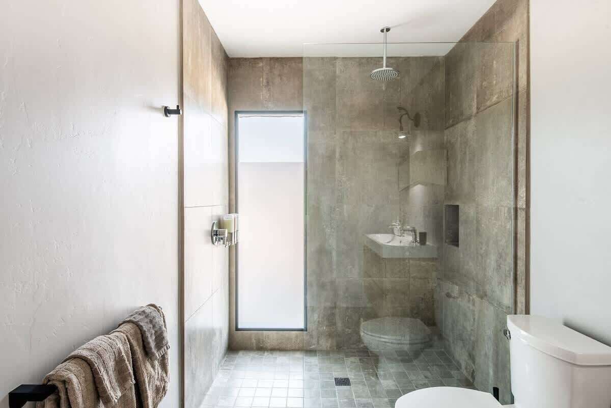 Une salle de bain moderne avec une douche à parois de verre, des toilettes et un lavabo.