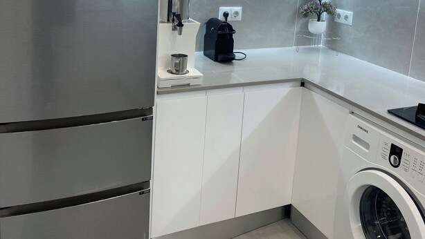 A modern kitchen with stainless steel appliances, a built-in washing machine, and a coffee maker. - Apartamento en Empuriabrava (Empuriabrava)