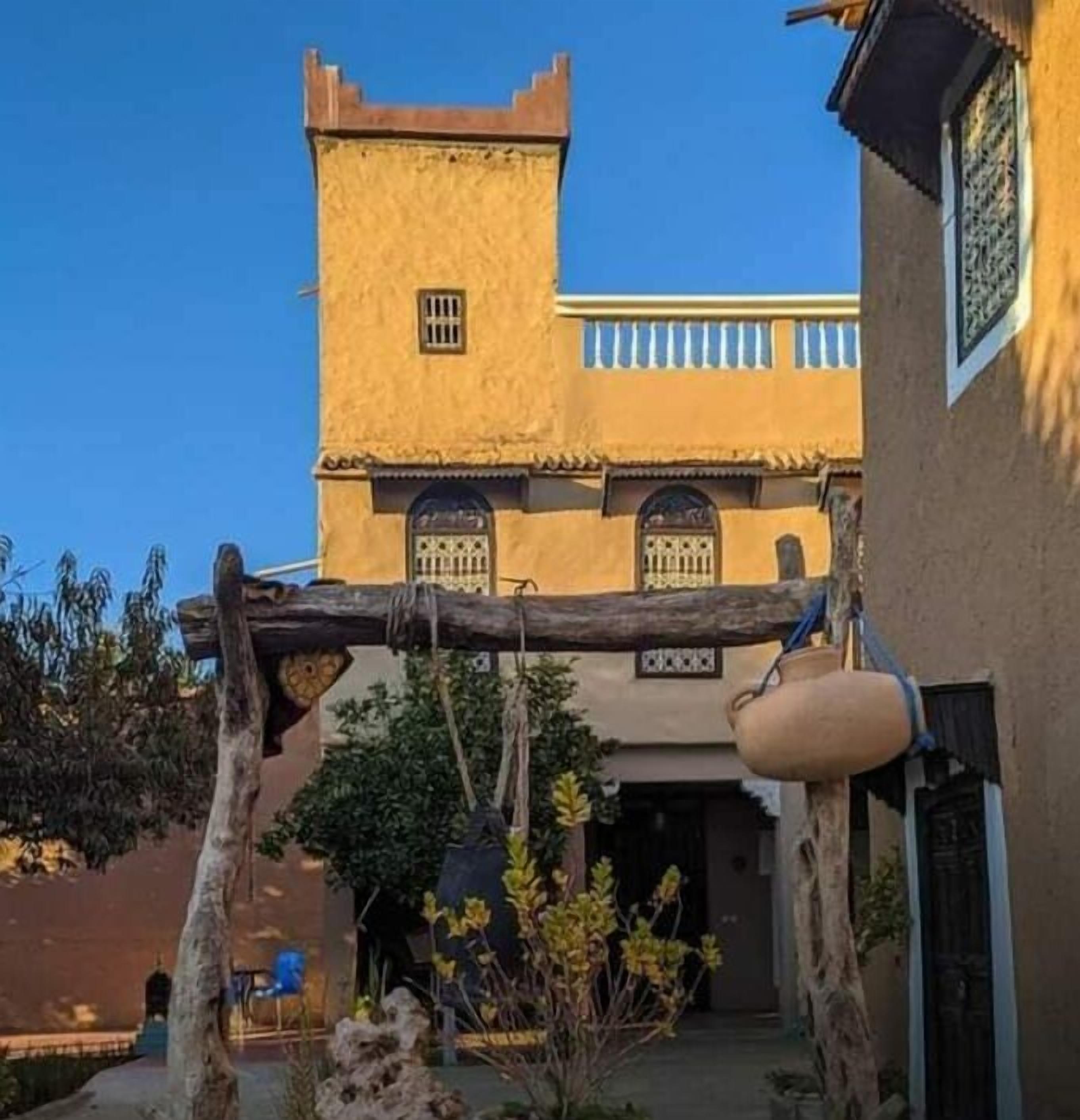 Un bâtiment traditionnel doté d’une tour, d’une cour et d’un récipient à eau suspendu.
