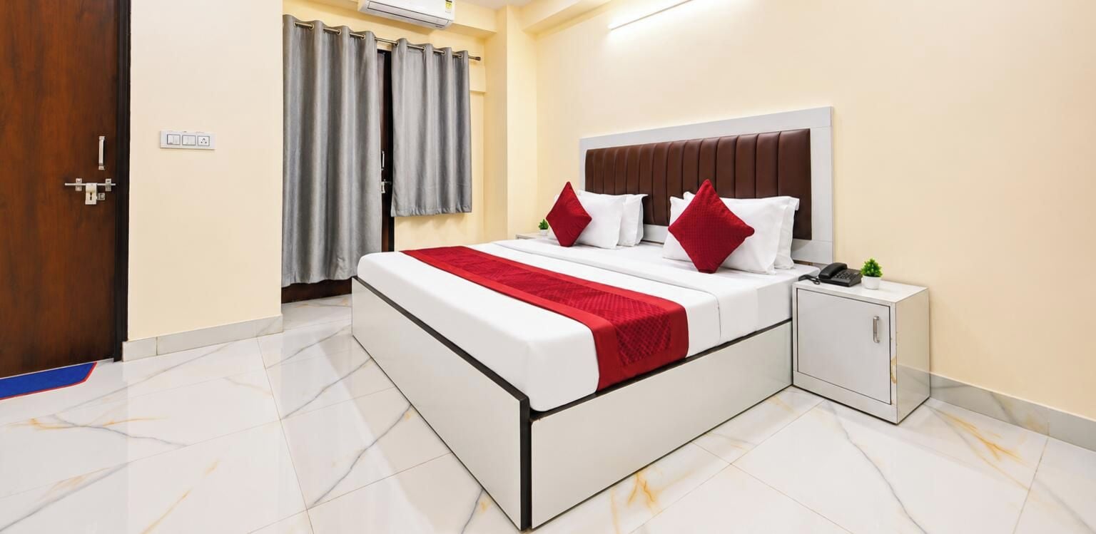 Una camera d'albergo con un letto, un comodino, un armadio e una porta.
