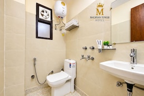 A bathroom with a toilet, bidet, and sink, with a showerhead and towel rack. - Mauryan Tower, Yashobhoomi (New Delhi)