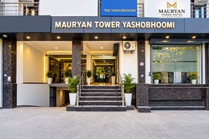 The exterior of the Mauryan Tower Yashobhoomi hotel with a modern entrance, marble steps, and potted plants. - Mauryan Tower, Yashobhoomi (New Delhi)