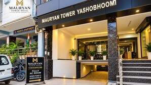 Das Außere des Mauryan Tower Hotels mit einem Schild, das den Standort des klimatisierten Zimmers angibt.