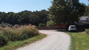 A rural road curving to the right with a white car parked on the side. - Mobilhome en Presquîle Guerandaise Pour 4 Personnes (Saint-Molf)