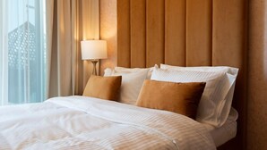 A hotel room with a large bed, a nightstand with a lamp, and a window with curtains. - Near Dubai Mall 1BR  Reva Residence (Dubai)