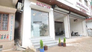 A hotel reception with a clear entrance, steps, and potted plants. - Hotel Shri Dhwaja Inn (Nathdwara)