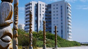 A modern high-rise building with multiple balconies and a clear sky. - Seaview Apartment with Balcony, 2 Bedrooms, Parking, Close to Beaches & Shops (Les Sables-d'Olonne)