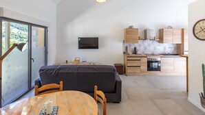 Eine moderne Küche mit Holzausstattung, einem Einbauofen und einem Essbereich mit Tisch und Stühlen.