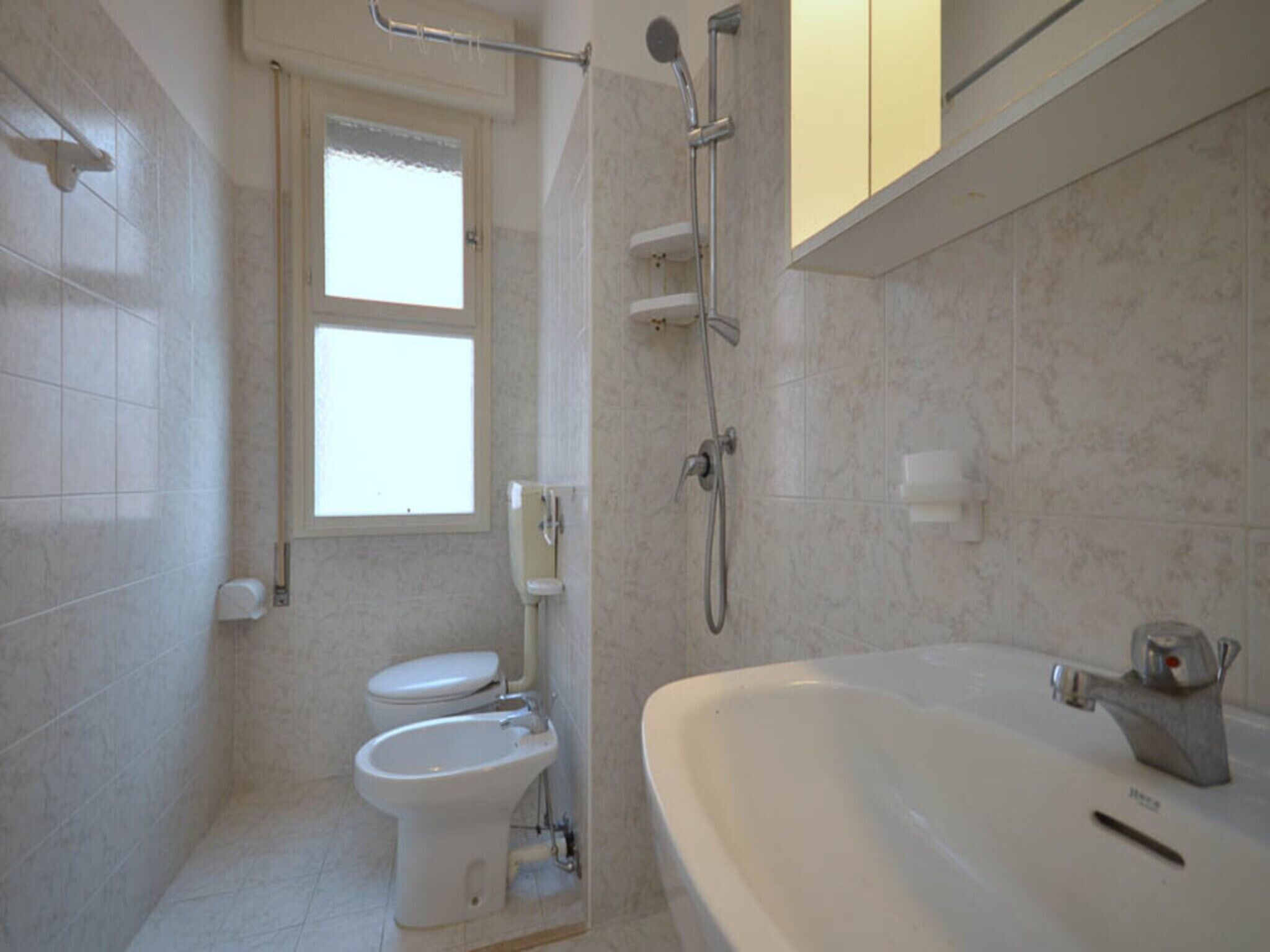 A bathroom with a toilet, bidet, and bathtub.