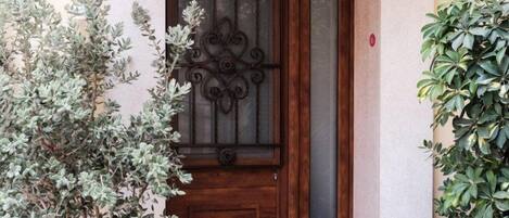 A wooden door with a decorative glass panel and a metal gate.