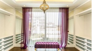 Una habitación con un ventanal grande, un banco y una araña.