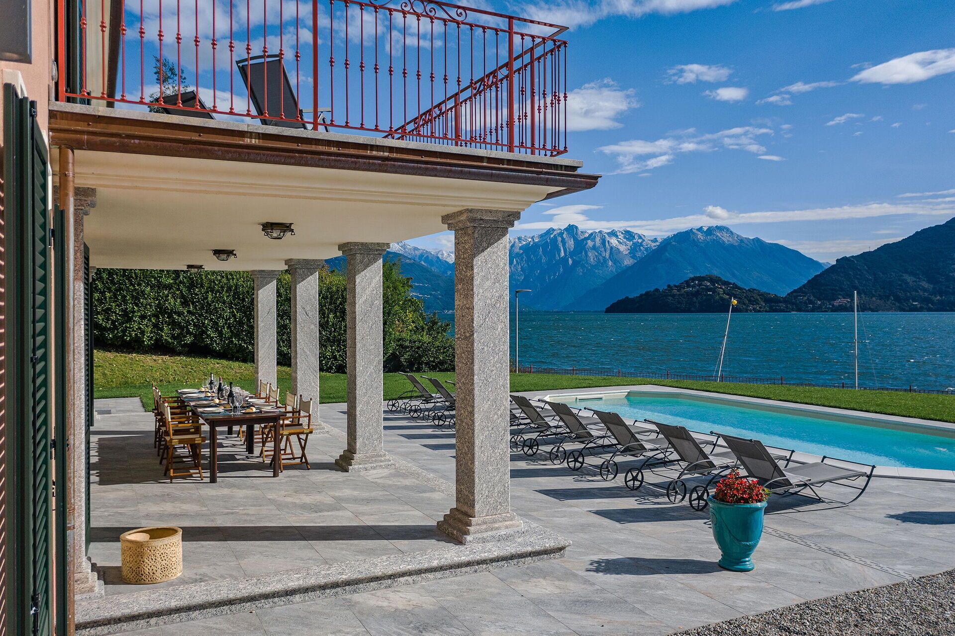 Une terrasse avec piscine, espace repas et vue sur les montagnes.