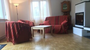 Un salon avec un canapé, une table et un téléviseur.