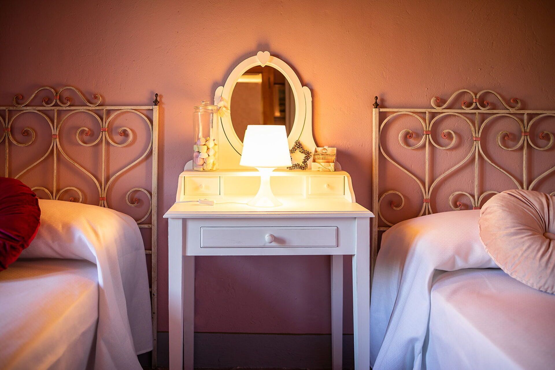Ein Schlafzimmer mit zwei Einzelbetten, einem Nachttisch mit Lampe und einem Spiegel.