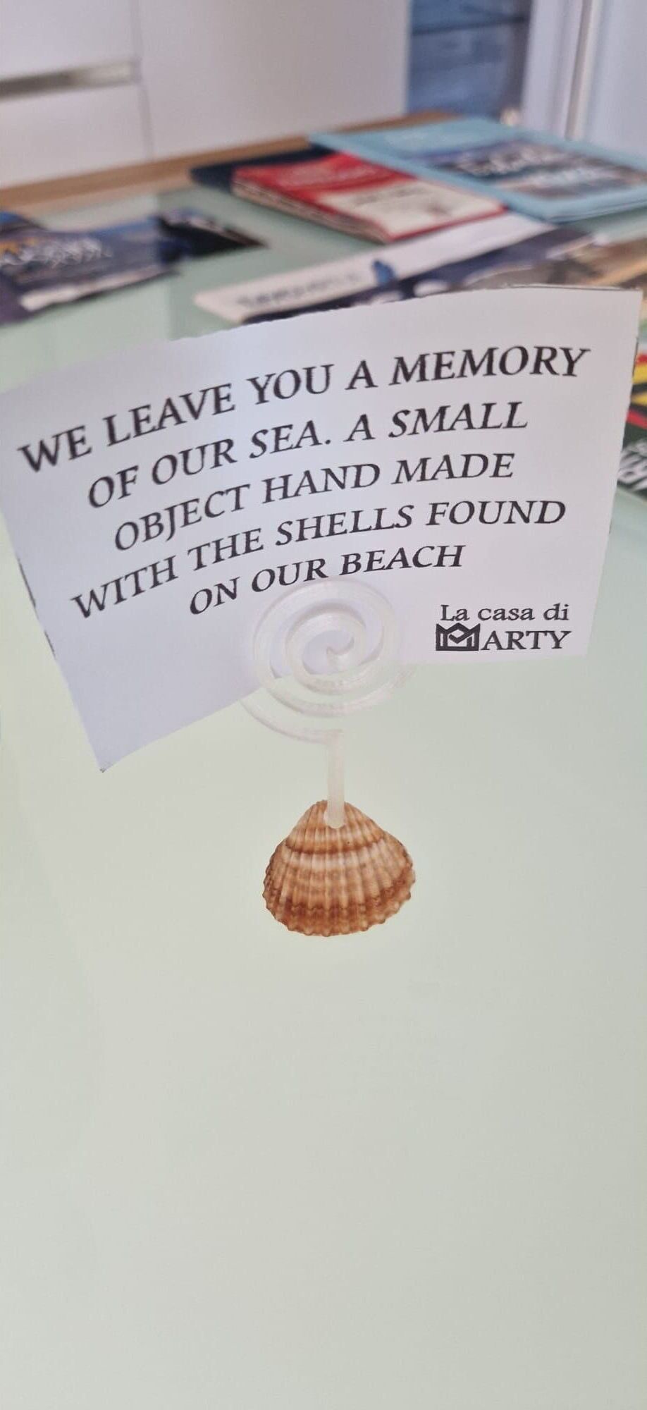A sign with a message about a sea shell and a small hand made object.