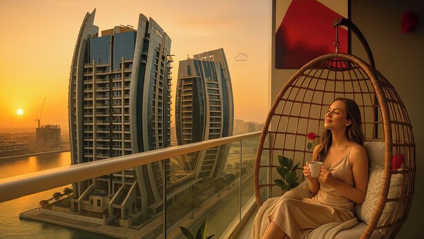 A person sitting in a wicker chair with a view of modern buildings and a body of water during sunset. - Modern City Scaping Apartment (Dubai)