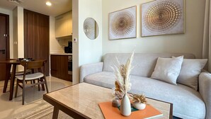 A modern living room with a sofa, coffee table, and artwork on the wall. - Modern City Scaping Apartment (Dubai)