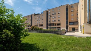 A multi-story residential building with a flat roof, a central courtyard, and a parking area. - Savena Terrace Apartment, in the heart of San Lazzaro (San Lazzaro di Savena)