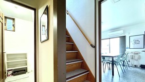 Un escalier menant à une pièce offrant une vue sur un espace extérieur.