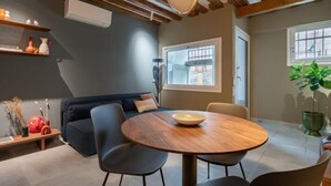 A modern living room with a round wooden table, dark blue sofa, and black chairs. - Venice Jewel Canal View by Wonderful Italy (Venice)