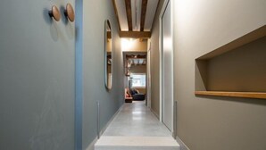 A narrow hallway with a staircase leading to an upper floor. The walls are painted in neutral tones, and there is a wooden beam ceiling. - Venice Jewel Canal View by Wonderful Italy (Venice)