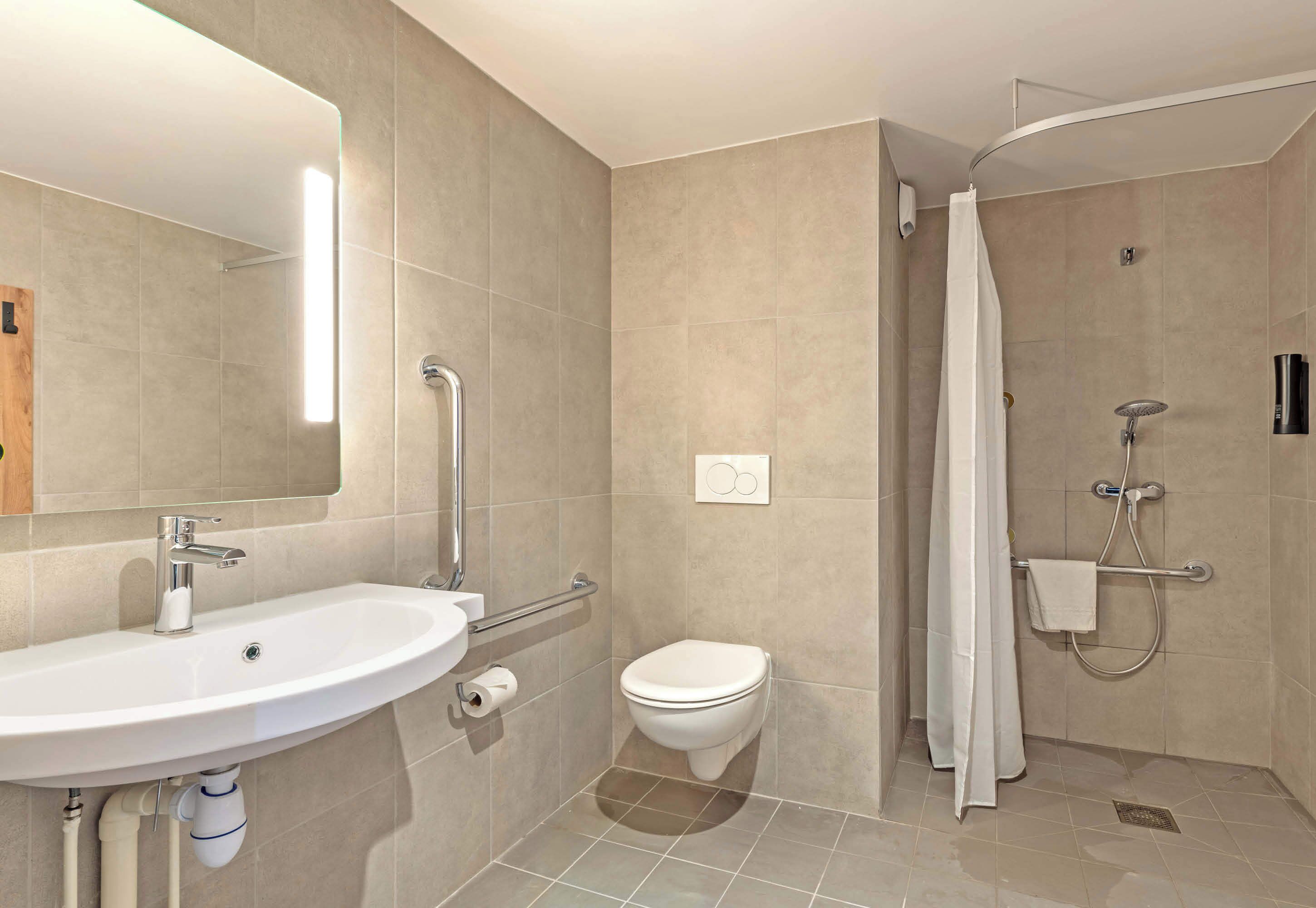 A modern bathroom with a sink, toilet, and shower.