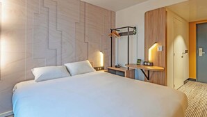 A hotel room with a large bed, a bedside table with a lamp, a mirror, and a wooden panel wall. - B&B Hotel Brest Porte De Gouesnou (Gouesnou)